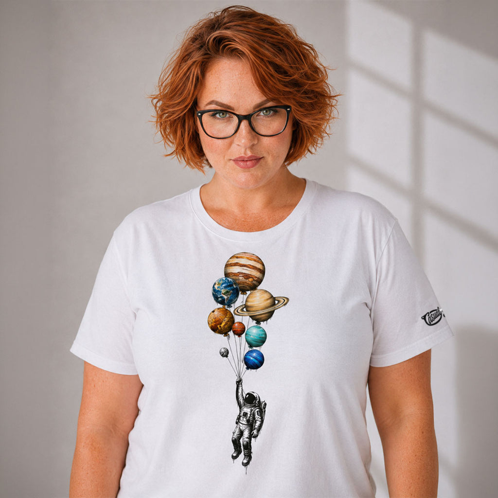 Person wearing a white t-shirt with a space-themed design of planets and an astronaut.