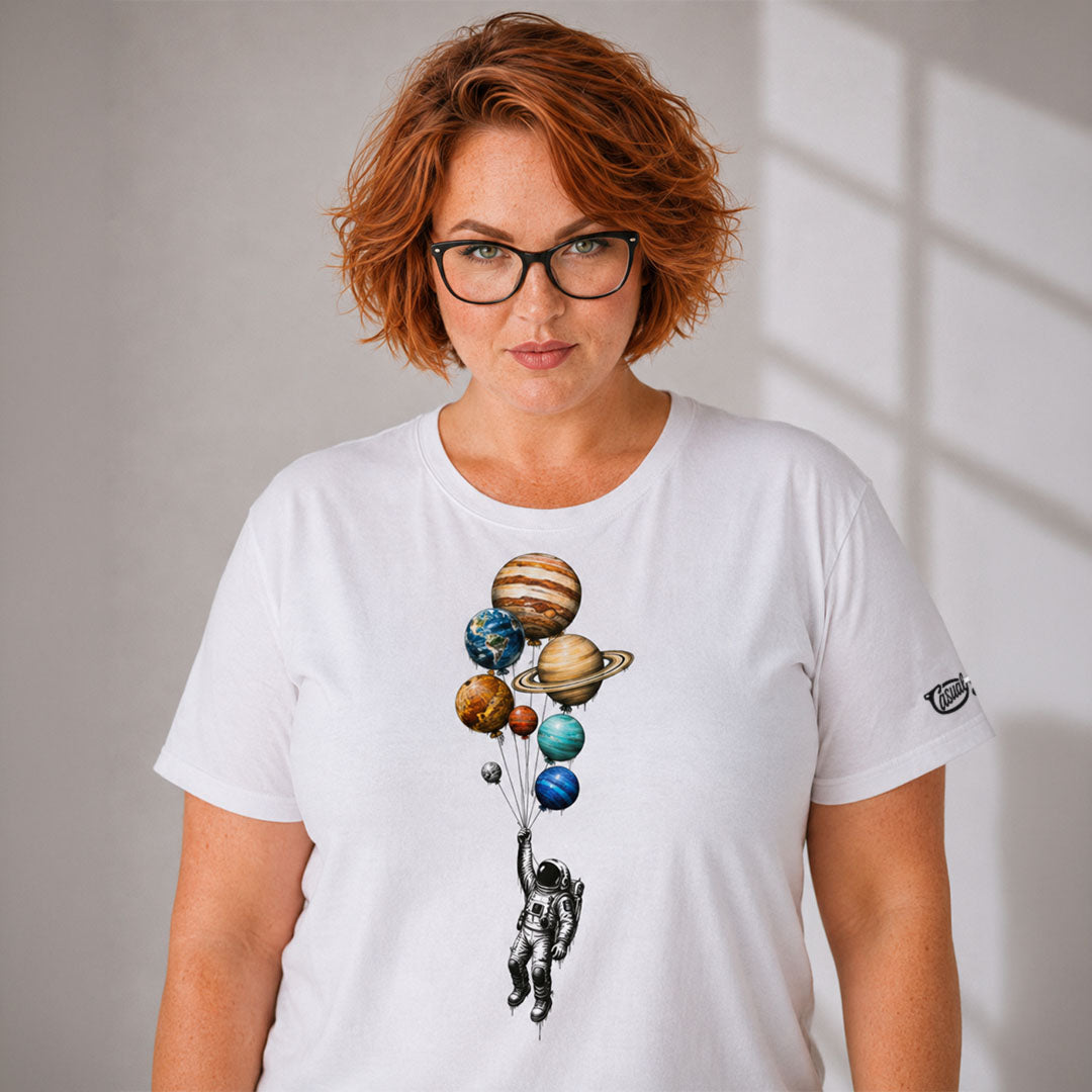 Person wearing a white t-shirt with a space-themed design of planets and an astronaut.