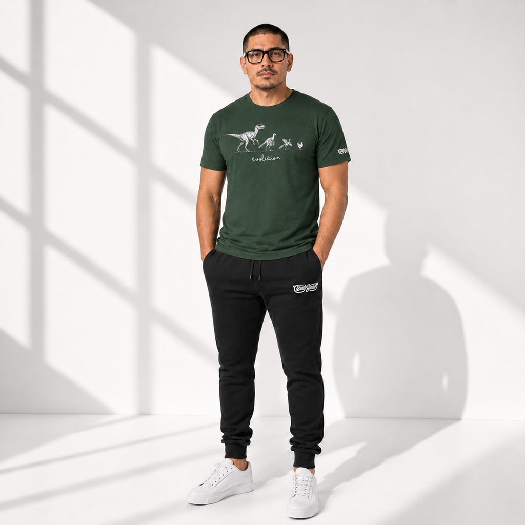 Man wearing a green t-shirt and black joggers with a Casual Genius brand logo, standing in a well-lit room.