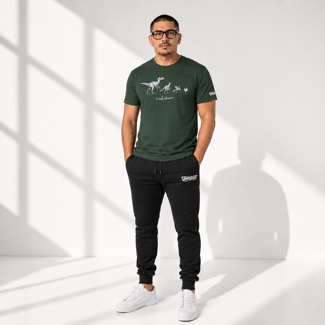 Man wearing a green t-shirt and black joggers with a Casual Genius brand logo, standing in a well-lit room.