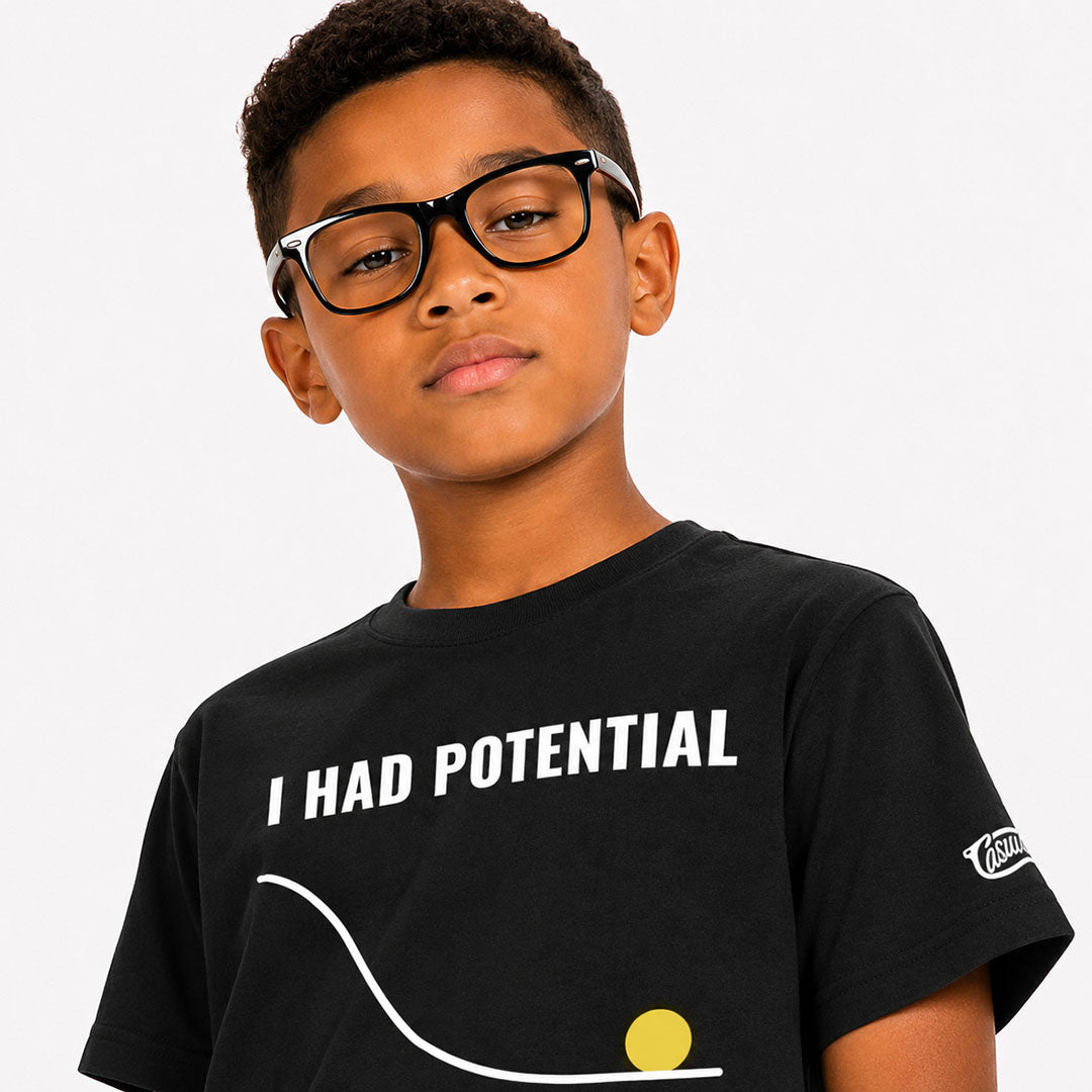 Child wearing a black t-shirt with 'I Had Potential' text on a plain background
