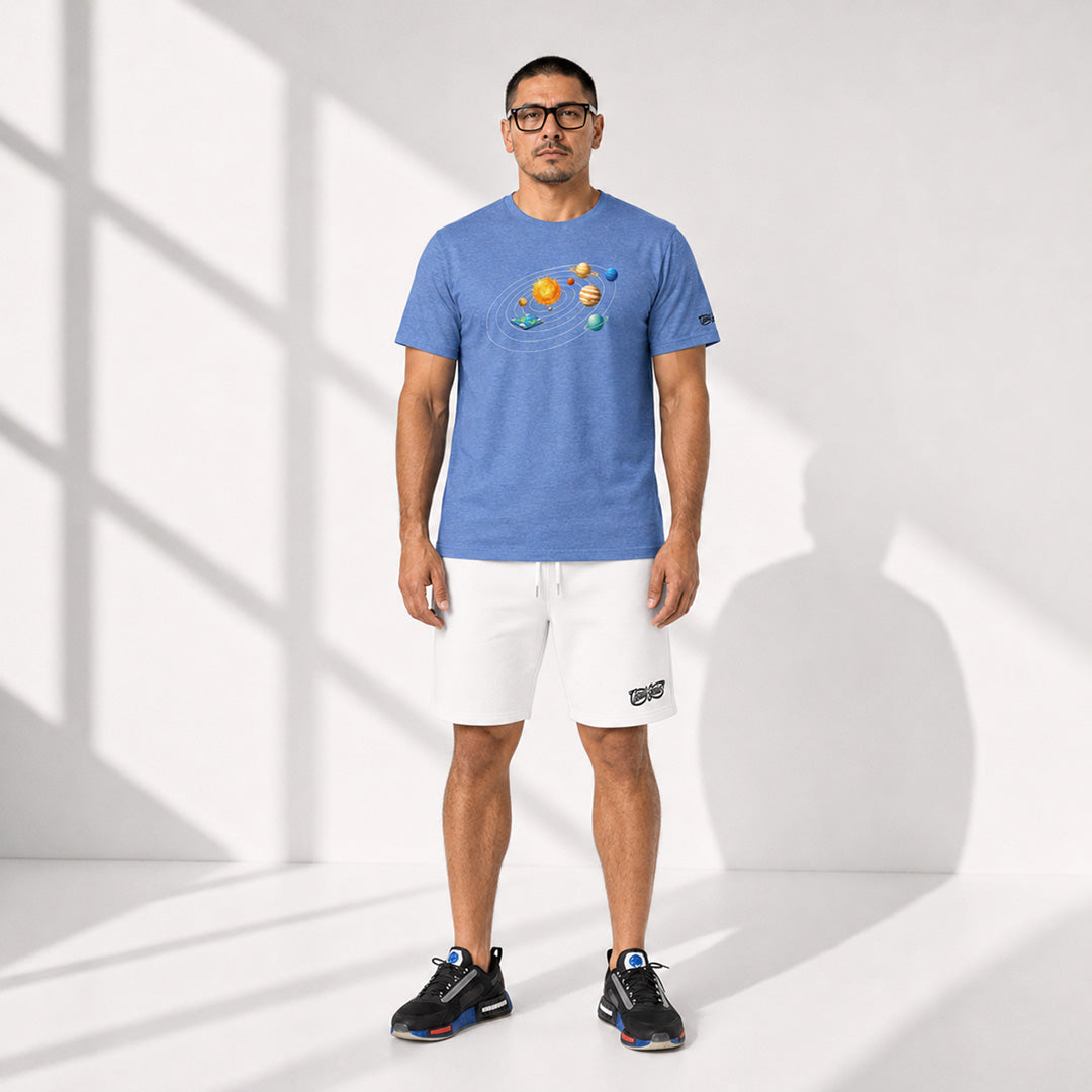 Man wearing a blue t-shirt with a graphic design and white shorts on a light background