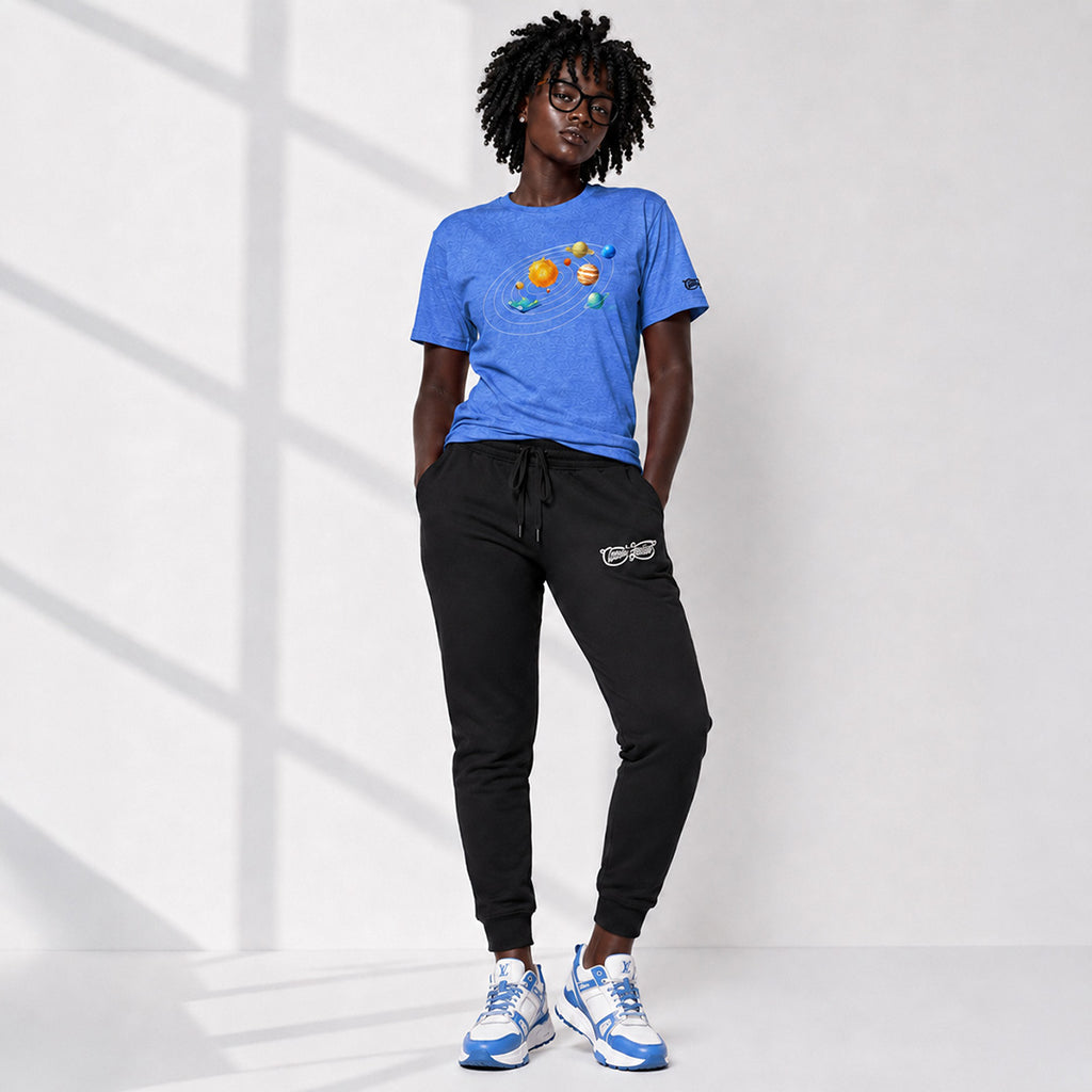 Person wearing a blue t-shirt with planet designs and black pants on a white background