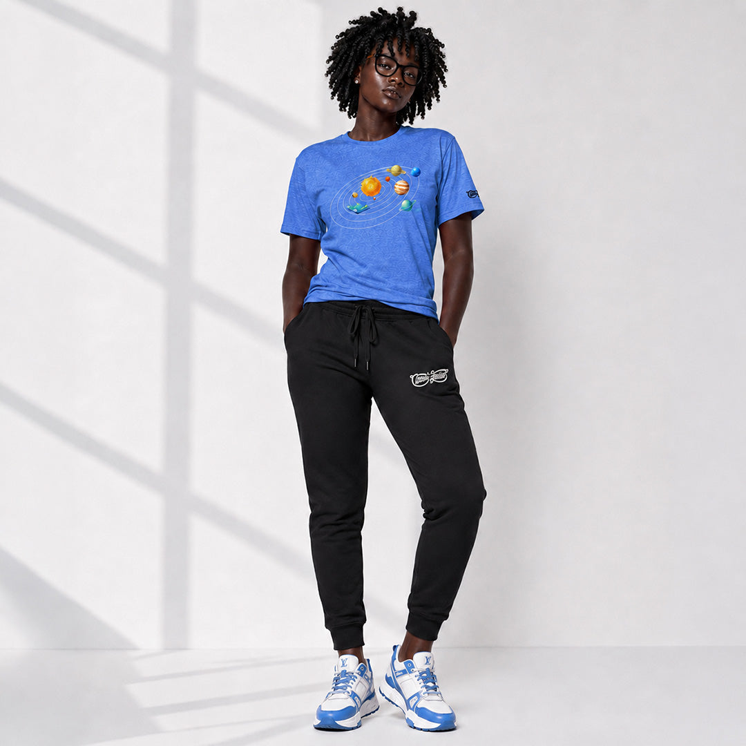 Person wearing a blue t-shirt with planet designs and black pants on a white background