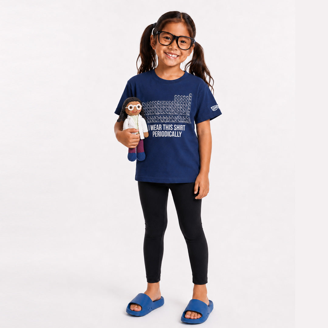 Young girl wearing a blue t-shirt with text, holding a doll, on a white background