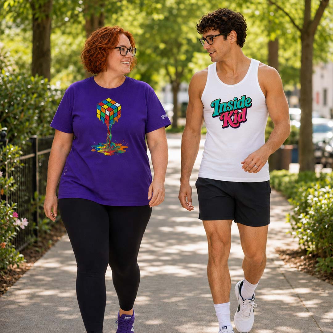Two people walking outdoors on a sidewalk with trees and buildings in the background.