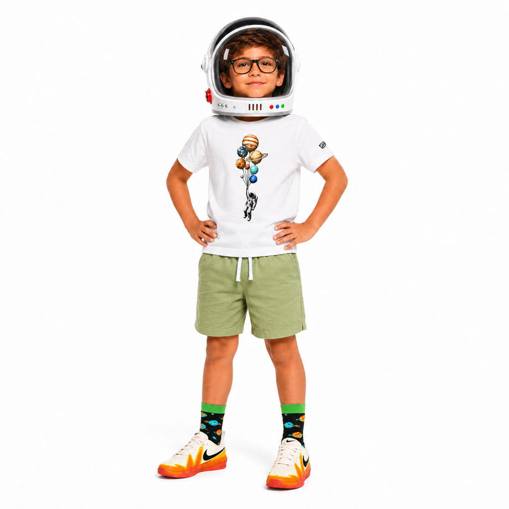 Child wearing an astronaut helmet and space-themed outfit on a white background