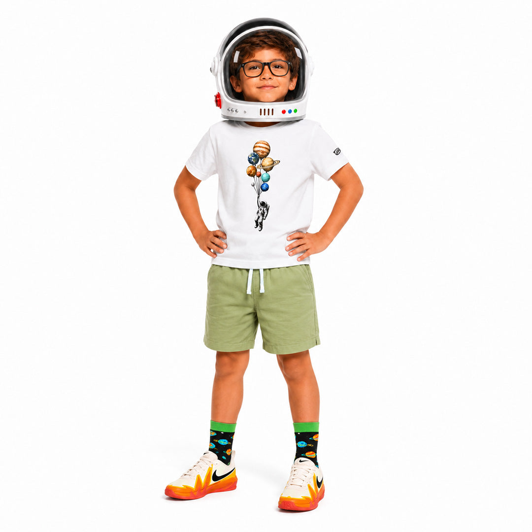 Child wearing an astronaut helmet and space-themed outfit on a white background